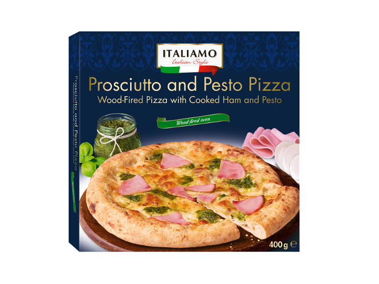 Pizza iz krušne peči s kuhano šunko in pestom, s kozarcem pesta in šunko ob strani.