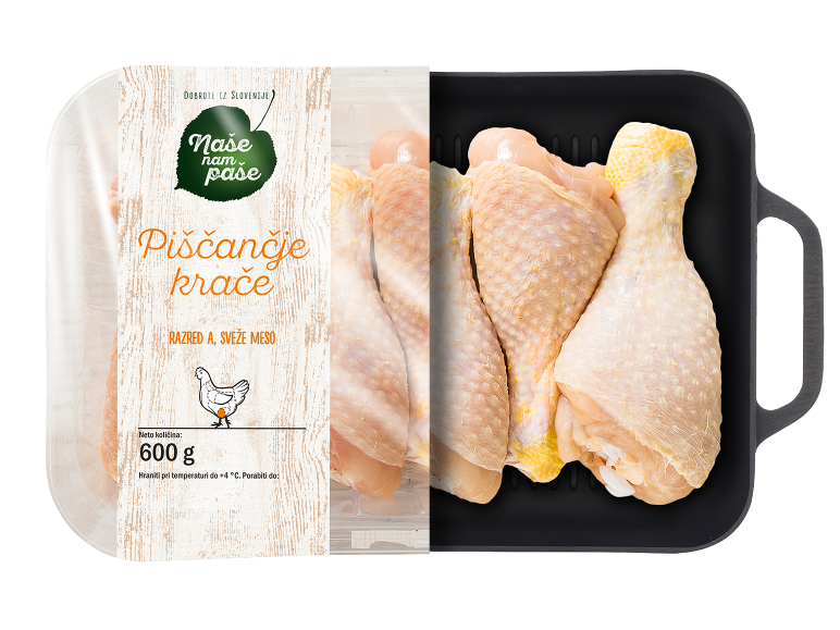 Pakirana sveža piščančja bedra z etiketo 600g, poleg črnega pekača.