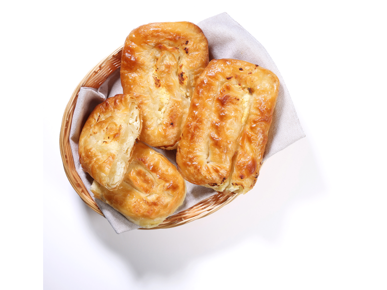 Sveže pečen sirov burek v pleteni košari na platneni krpi.