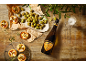 Mini pice in olive s steklenico Prosecca in kozarcem na leseni mizi.