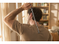 Moški uporablja teleskopsko praskalnik za hrbet v dnevni sobi.