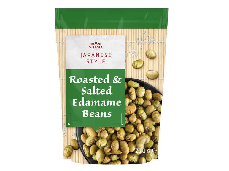 Vrečka praženega in soljenega edamame fižola v japonskem slogu na bambusovi podlogi.