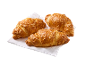 Trije zlato rjavi rogljički s sirom na beli papirnati brisači.