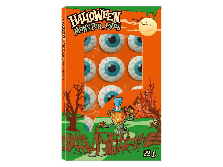 Halloween bonboni v obliki pošastnih oči v oranžni škatli z jesensko dekoracijo.