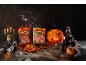 Halloweenski sadni bonboni v vrečkah, buče, sveče in pajčevine na temnem ozadju.