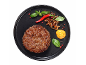 Goveji burger s karamelizirano čebulo, čilijem, baziliko in gorčično omako na črnem krožniku.