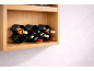 Lesen regal za vino s šestimi steklenicami rdečega in belega vina v črnem, valovitem držalu.