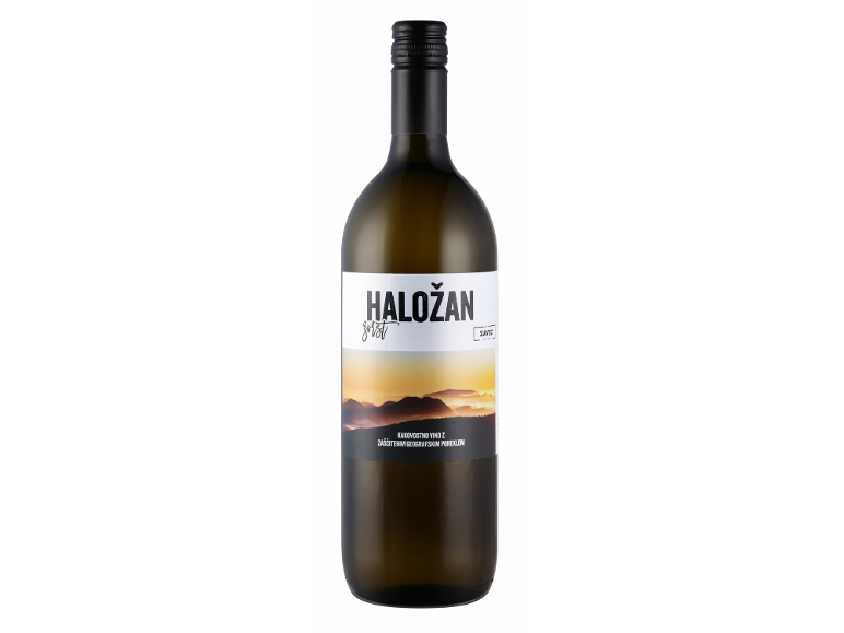 Steklenica belega vina z etiketo, ki prikazuje gorsko pokrajino ob sončnem zahodu.