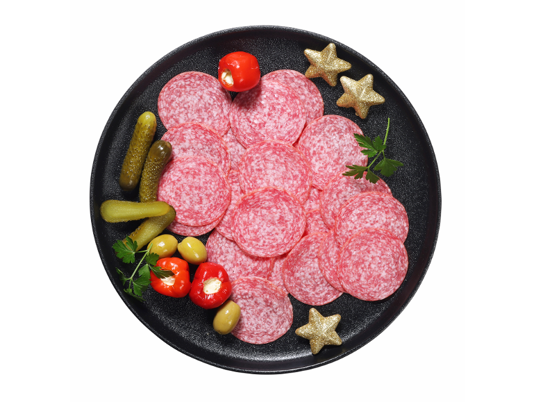 Krožnik salame s kumaricami, olivami, polnjenimi paprikami in zvezdnimi okraski.