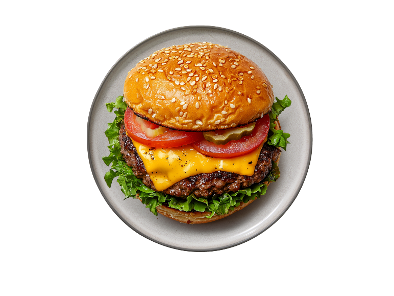 Klasičen burger s sirom, paradižnikom, kumarico in solato na krožniku.
