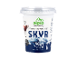 Bela posoda za jogurt z modro gorsko pokrajino in besedilom, kot sta »Skyr« in »40g beljakovin«.