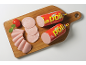 Pakirane in narezane piščančje klobase, s paradižnikom in meto na leseni deski.