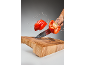 Rdeča paprika se reže v zraku z brizgi vode nad leseno desko za rezanje.