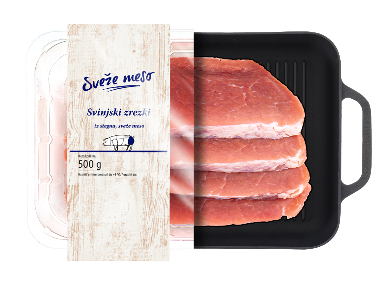 Sveži svinjski zrezki v pakiranju, 500 g, s črno žar ponevjo ob strani.