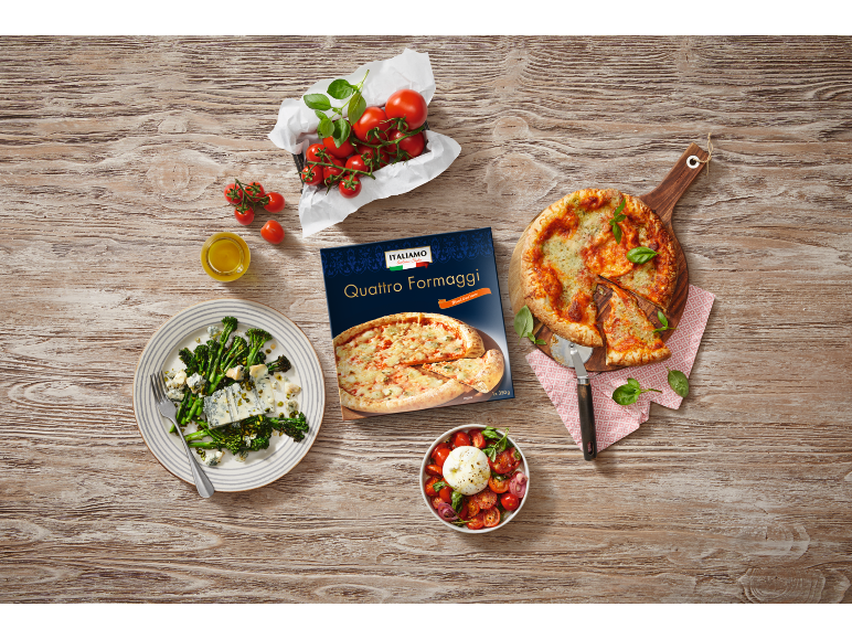 Pizza štirje siri s paradižnikom, brokolijem in solato mocarele na leseni mizi.