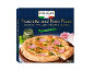 Pizza iz krušne peči s kuhano šunko in pestom, s kozarcem pesta in šunko ob strani.