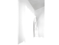 Minimalistična notranjost z belimi stenami in črnimi sencami, ki ustvarjajo geometrijske oblike.