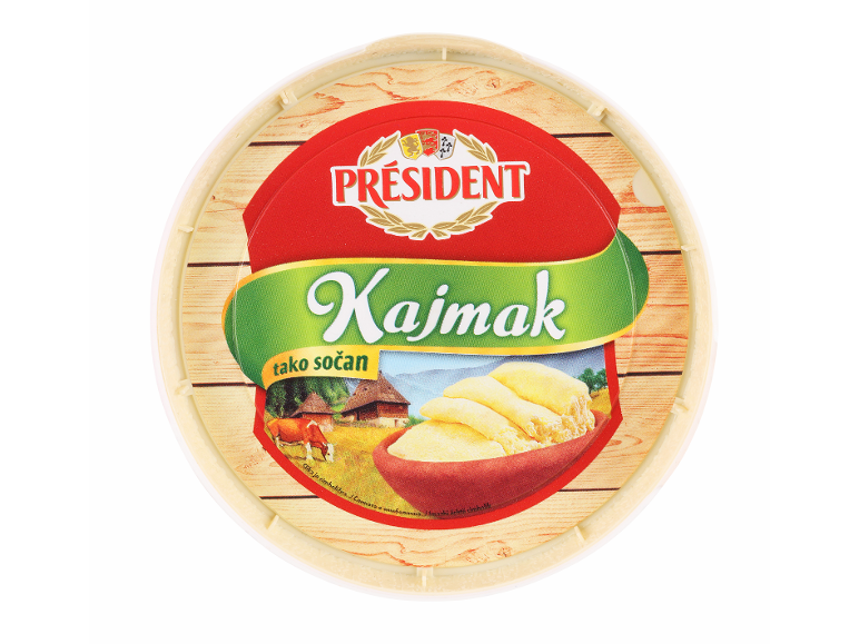 Okrogla embalaža kajmaka s podeželsko pokrajino in kravo.