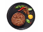 Goveji burger s karamelizirano čebulo, čilijem, baziliko in gorčično omako na črnem krožniku.