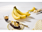 Sveže banane, kos čokoladne torte z banano in pistacijami ter kava.