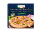 Pizza iz krušne peči s kuhano šunko in pestom, s kozarcem pesta in šunko ob strani.