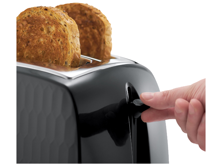 Črn opekač kruha z dvema rezinama polnozrnatega toasta, prst pritiska ročico.
