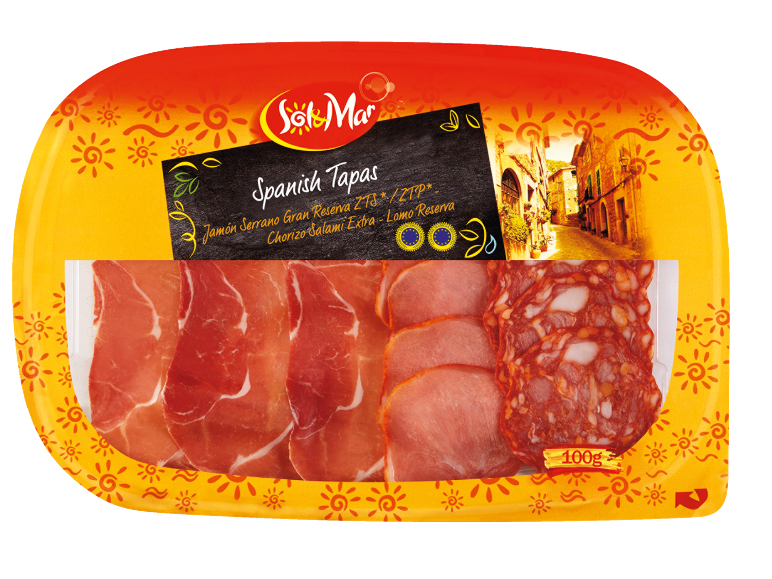 Pladenj španskih tapasov s serrano pršutom, chorizom in svinjsko ribico, z ozadjem španske ulice.