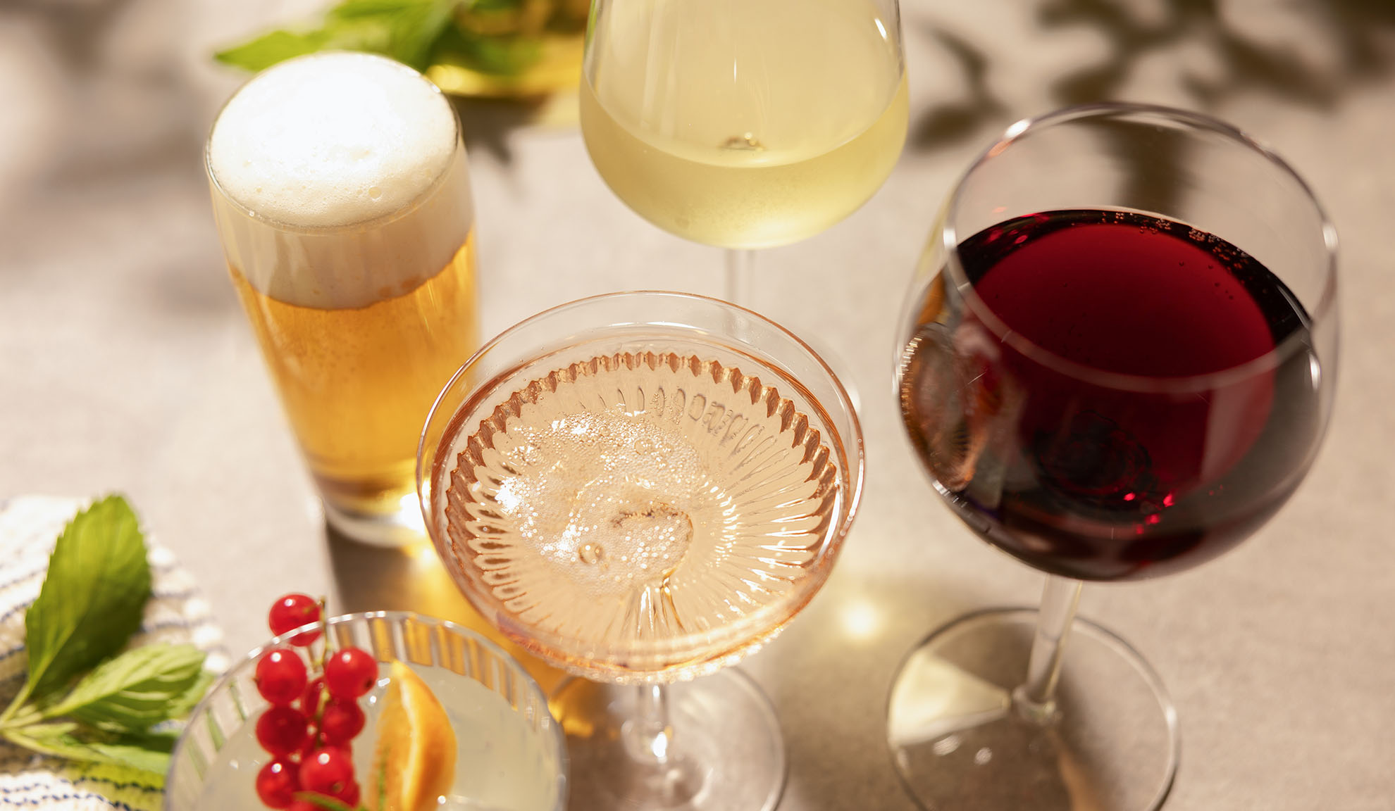 Kozarci piva, belega, rosé in rdečega vina, s koktajlom in jagodičevjem.
