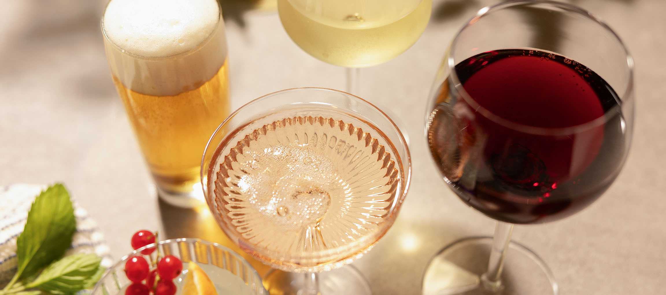 Pivo, rose vino in rdeče vino v kozarcih, z jagodičevjem in meto.