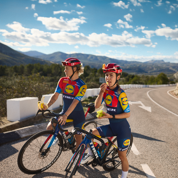 Dve kolesarki ekipe Trek-Segafredo Lidl uživata v odmoru s sadjem.