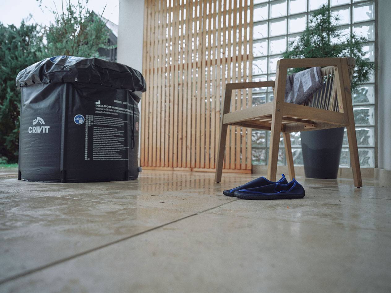 Napihljiv bazen Crivit in čevlji za v vodo na terasi.