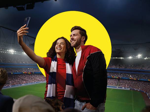 Par si dela selfi na nogometnem stadionu.