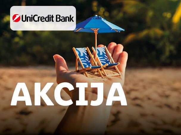 Roka drži miniaturni ležalnik in senčnik na peščeni plaži, z napisom AKCIJA.