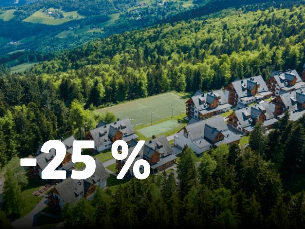 Panoramski pogled na gorsko letovišče s hišami in teniškimi igrišči, z napisom -25%.