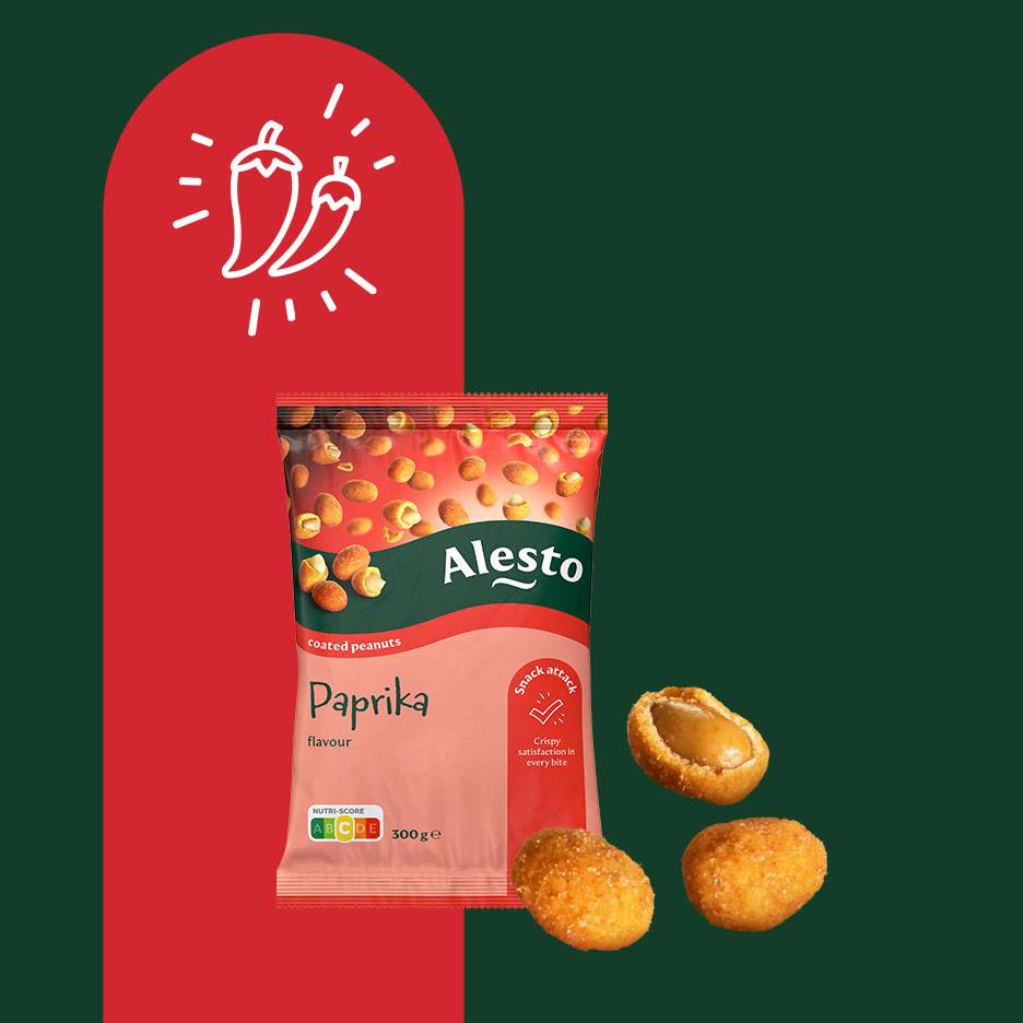 Paket arašidov s papriko in trije arašidi, eden odprt, na rdečem in zelenem ozadju.