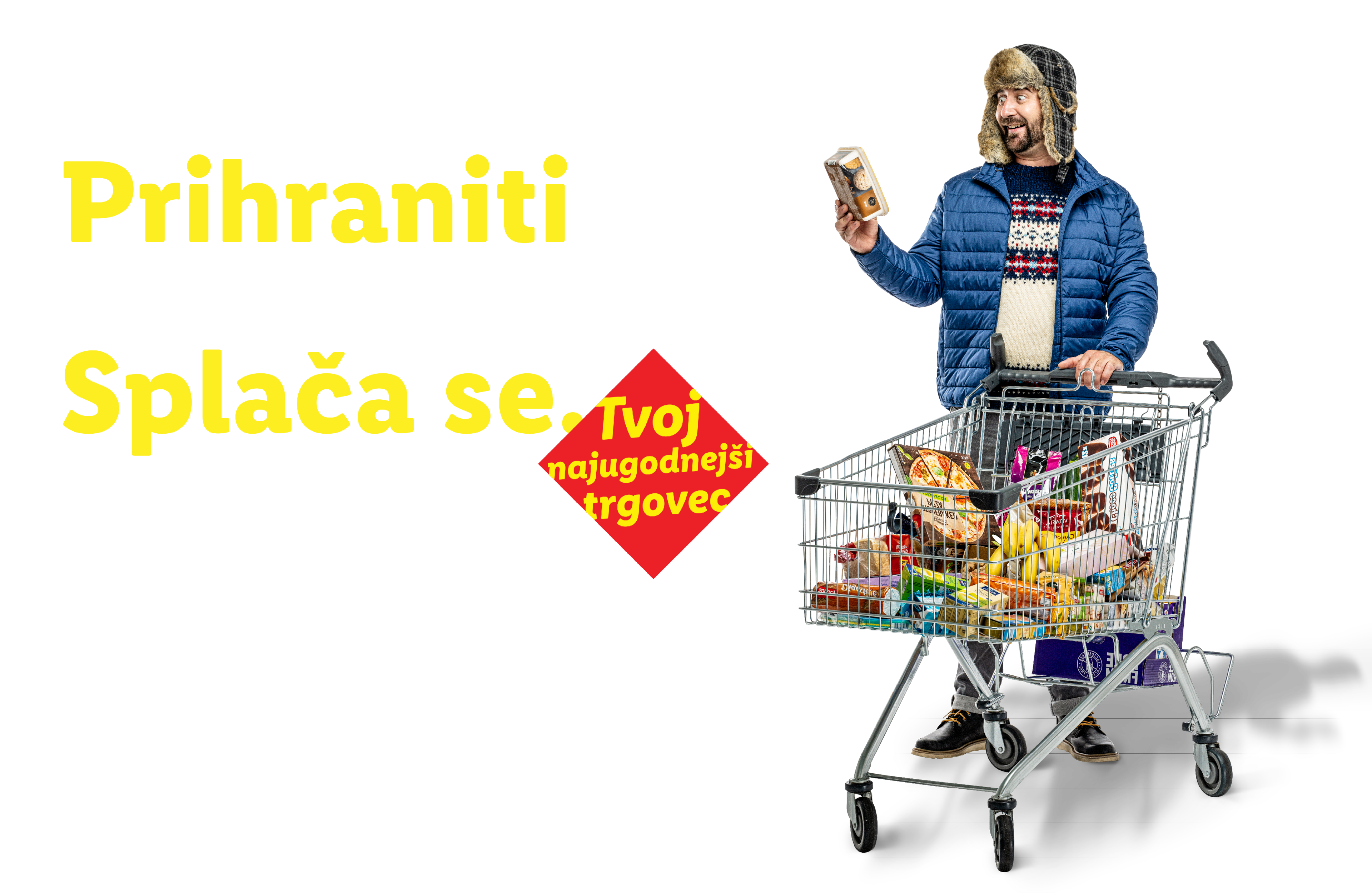 Moški v zimski kapi in jakni s polnim nakupovalnim vozičkom, z napisom »Prihraniti v vsakem letnem času? Splača se.«