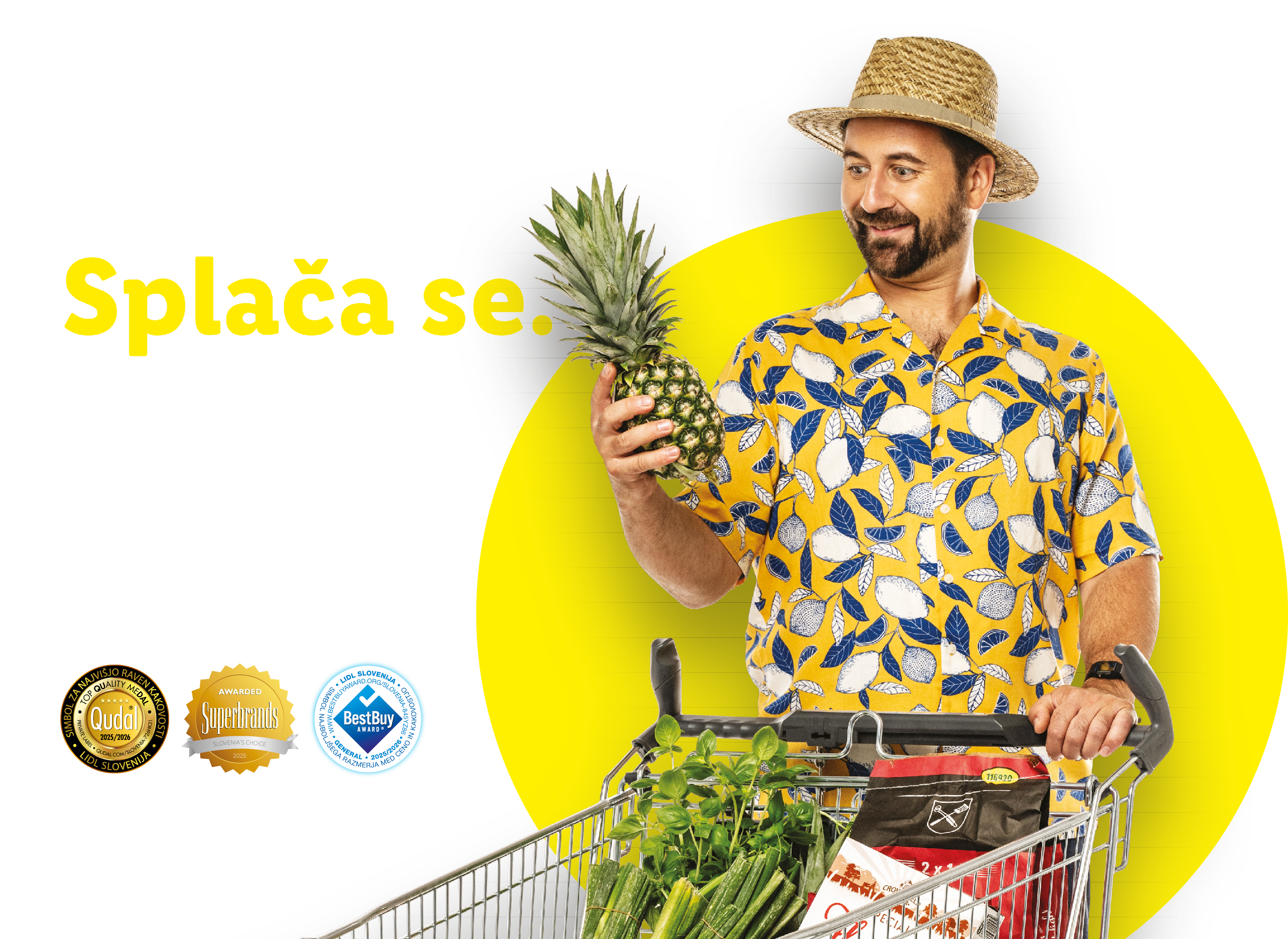 Moški s polnim nakupovalnim vozičkom in ananasom, obdan z nagradami Qudal, Superbrands in BestBuy.