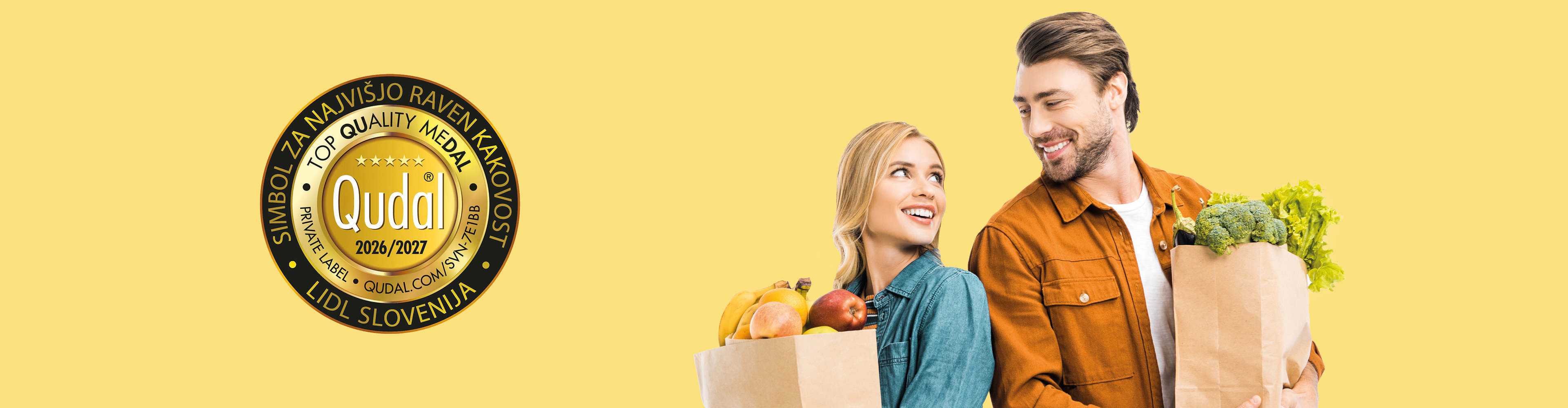 Nasmejan par drži nakupovalne vrečke s sadjem in zelenjavo, ob strani je zlata medalja za kakovost.