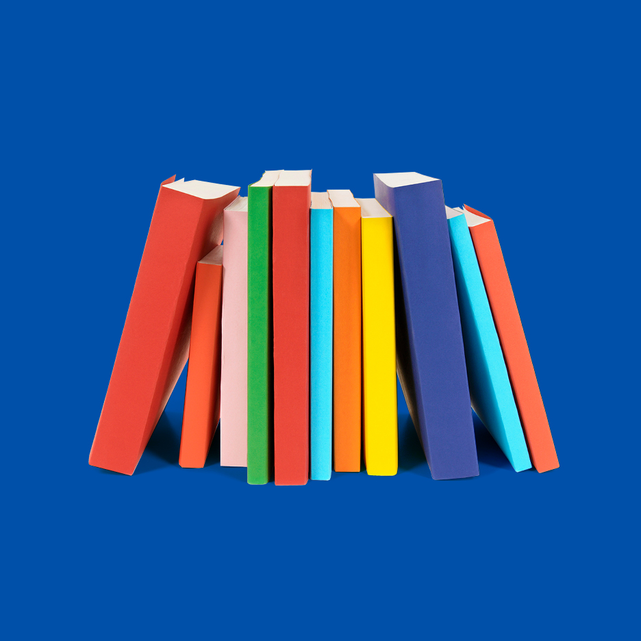 Pisane knjige, zložene v vrsto na modrem ozadju.