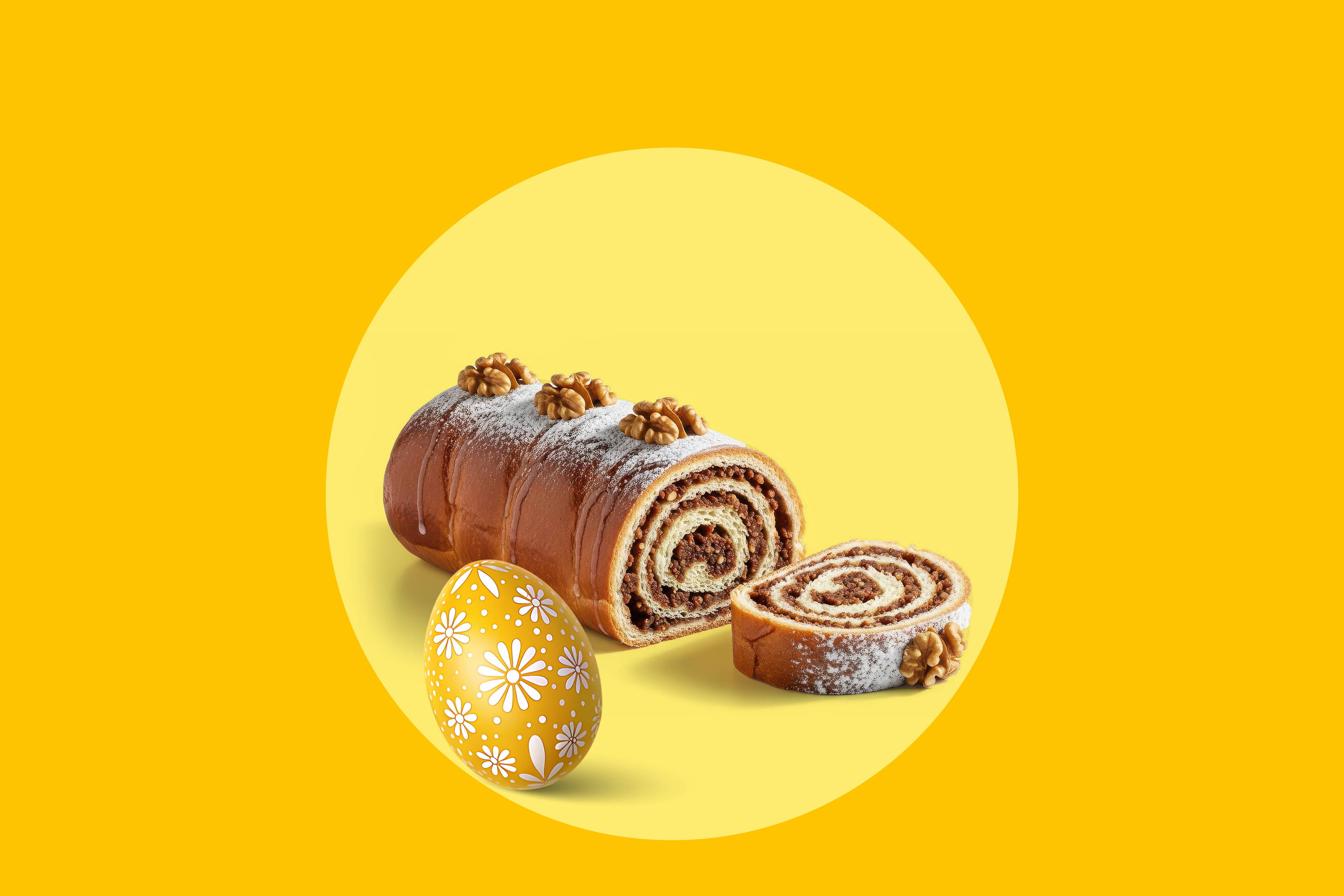 Orehova potica in pisano velikonočno jajce na rumenem ozadju.