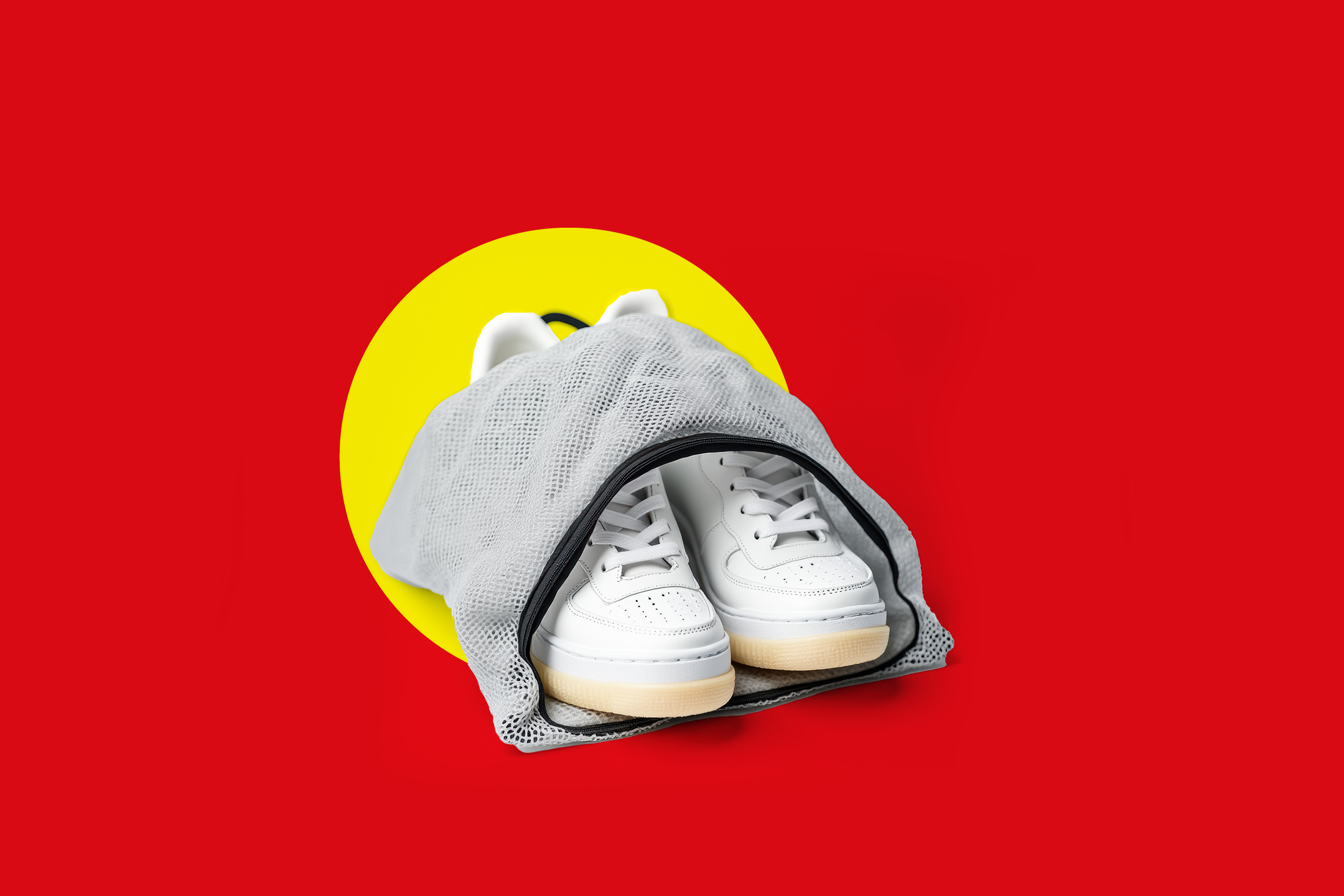 Bele superge v mrežasti vrečki za pranje perila na rdečem ozadju z rumenim krogom.