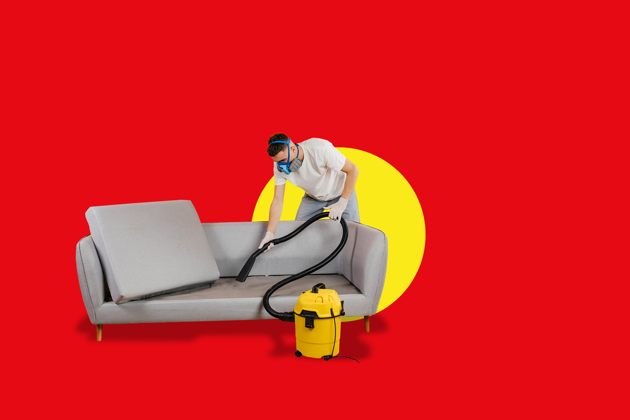 Moški čisti kavč z rumenim sesalnikom.