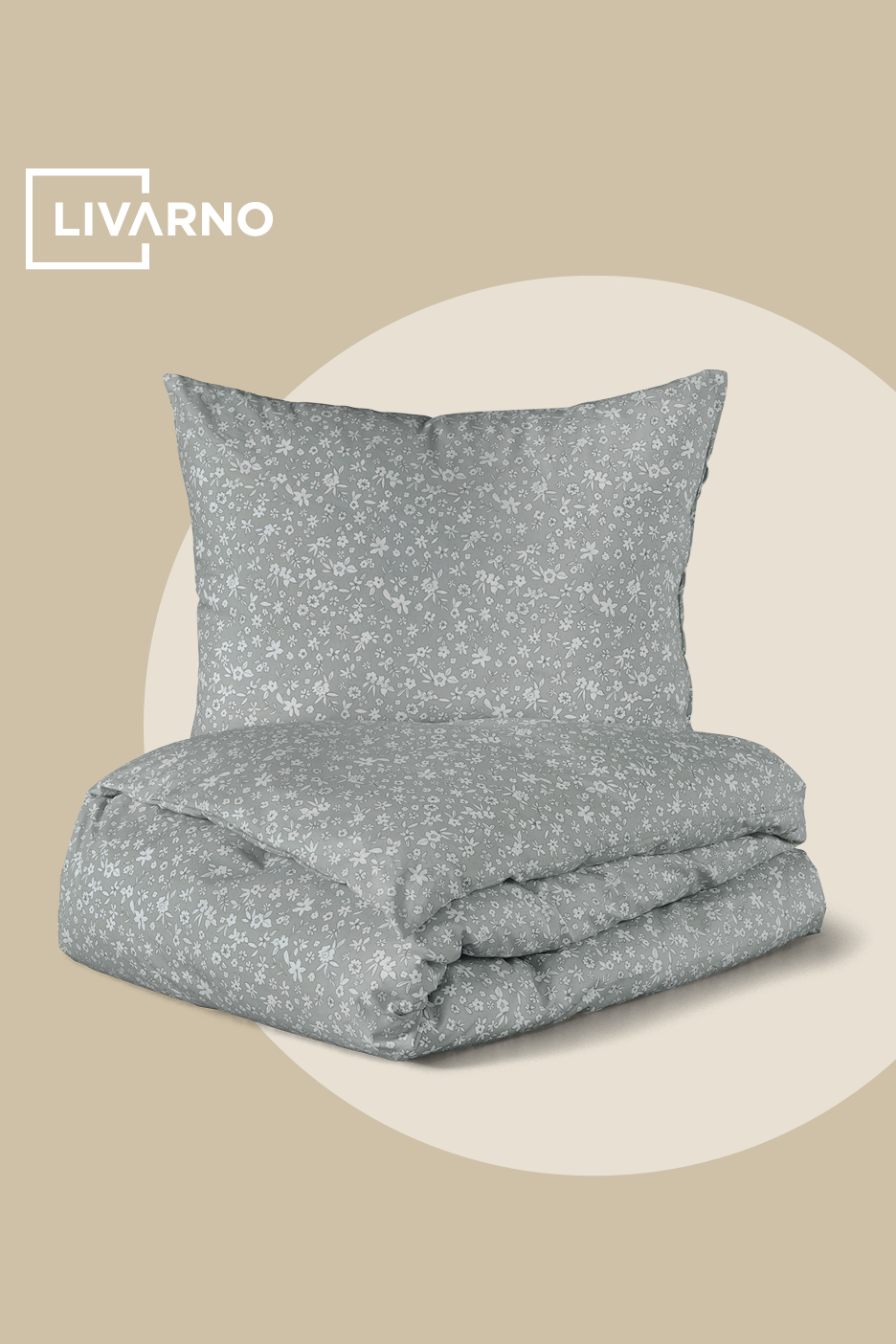 Svetlo siva posteljnina z drobnim belim cvetličnim vzorcem, zložena na bež ozadju.