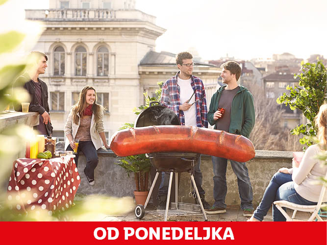 Prijatelji se zabavajo na strehi, pečejo ogromno klobaso na žaru.