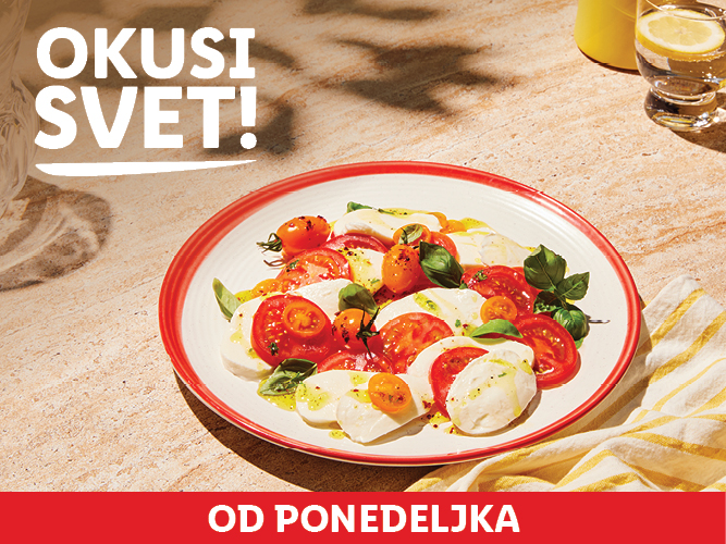 Caprese solata s paradižnikom, mocarelo in baziliko na mizi.