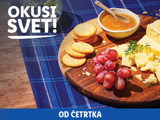 Sir, krekerji, grozdje in marmelada na leseni deski, z napisom 'OKUSI SVET!'