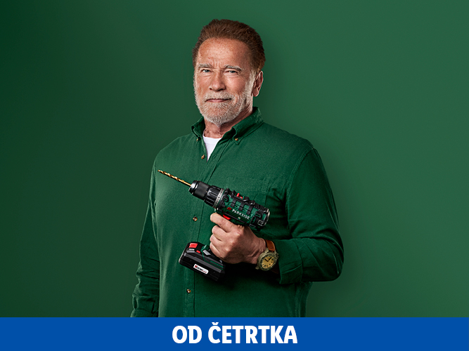 Arnold Schwarzenegger drži Parkside vrtalnik na zeleni podlagi.