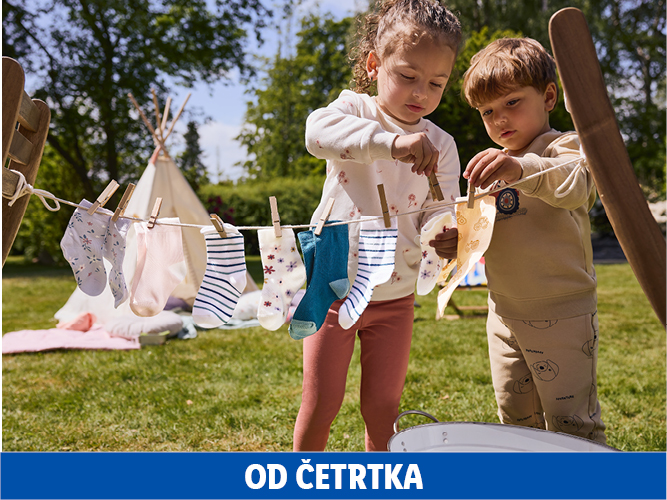 Otroka obešata perilo na vrvico, v ozadju šotor.
