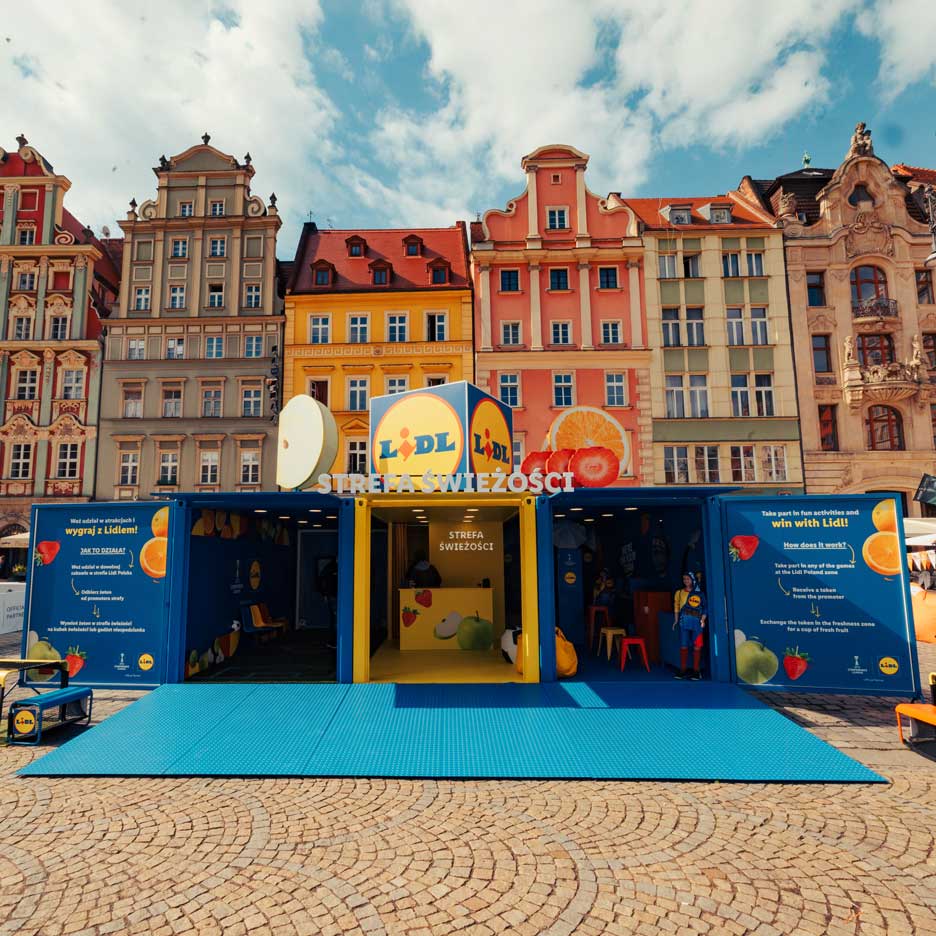 Lidl instalacija na temo sadja in zelenjave, z igrami in dejavnostmi, na mestnem trgu.
