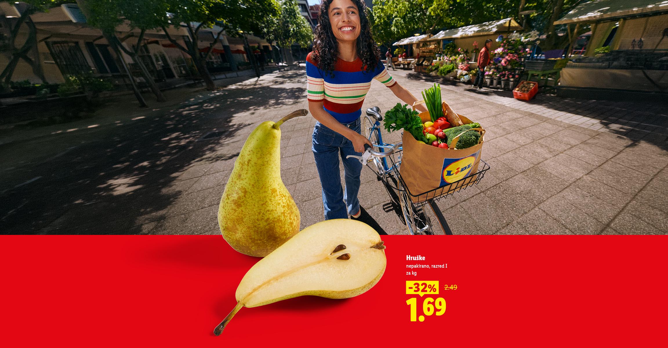 Sveže hruške na rdečem ozadju s popustom in oseba s kolesom ter nakupovalno vrečko.